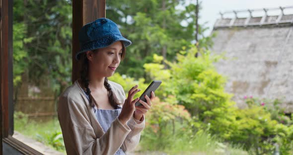 Woman use of mobile phone in the old Japanese house