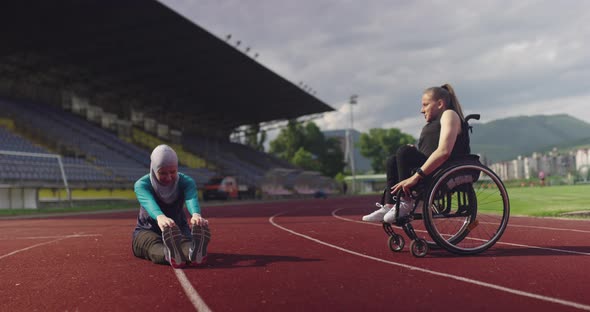 A Female Person with Disabilities Warming Up on Wheelchair at Athletics Training Track with Muslim