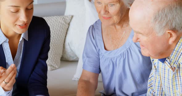 Front view of senior Caucasian couple meeting with real estate agent in a comfortable home 4k