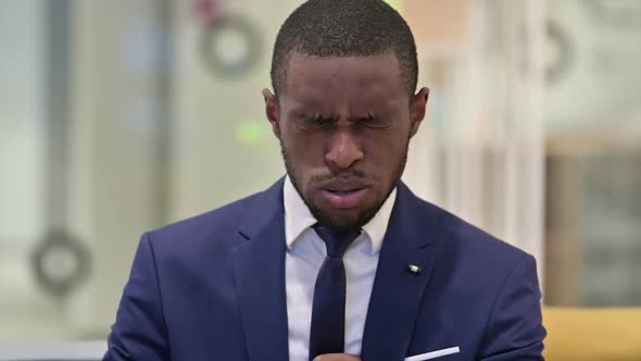 Portrait of Sick African Businessman Coughing
