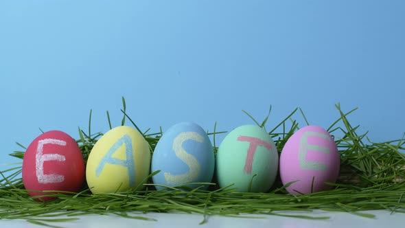 Man swaps an Easter bunny for a multicolored egg isolated on a blue background