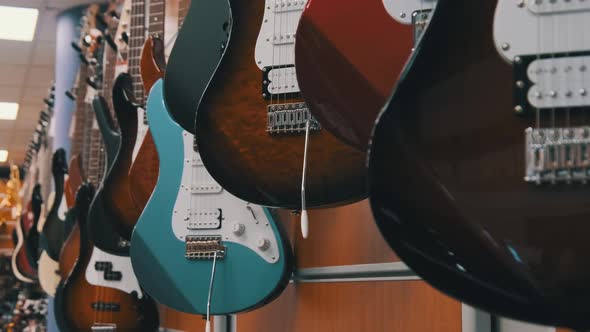 Lot of Multicolored Electric Guitars Hanging in a Music Store Guitar Shop