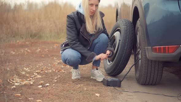 Checking Tire Pressure. Pumping Air Into Auto Wheel. Electric Pump Inflates Pressure Gauge For Car.