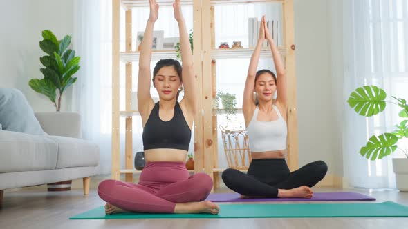 Asian active woman friend doing Yoga Pilates workout together at home.