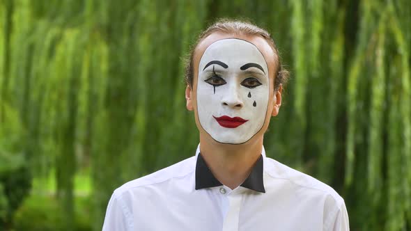 Fun Mime Looking at the Camera on Green Background in a Park