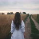 Beautiful Girl with Long Hair Walks Through Wheat Field in Summer Touching Ears of Wheat with Her - VideoHive Item for Sale