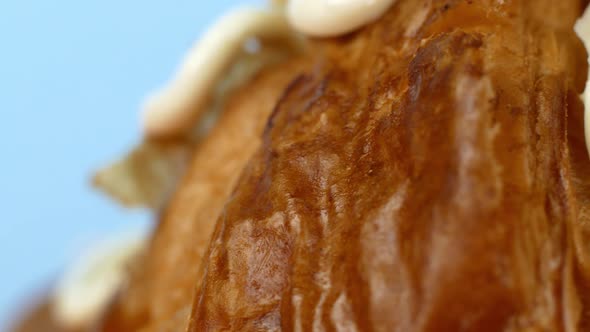 Macro shot of a croissant dessert on a blue background. Baking, dessert with coffee.
