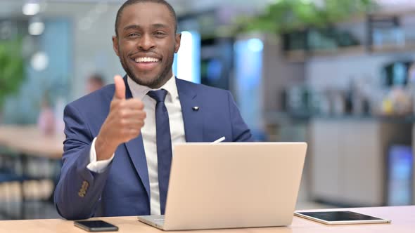 African Businessman with Laptop Doing Thumbs Up in Office 