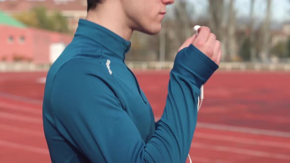 Handsome Sportive Young Man Runner Putting On Earphones.