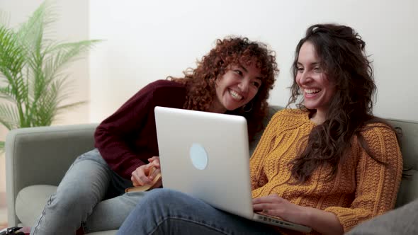 Happy Gay Couple of Women Having Fun Using Computer Laptop at Home LGBT Lesbian Relationship Concept