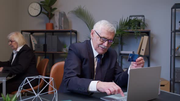 Senior Businessman Grandfather Director Shopping Online and Paying with Credit Card in Modern Office