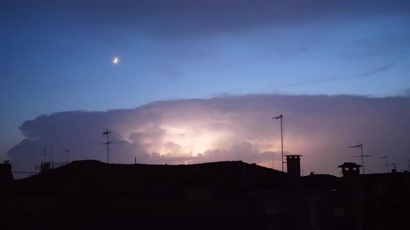 Thunderstorm on a night sky over the city rooftops