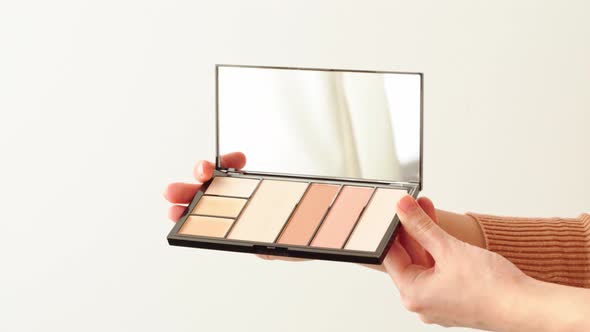 Female Hands Presenting Make Up Palette with Face Foundation