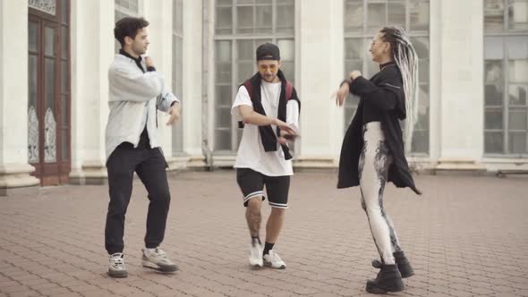 Wide Shot of Positive Millennial Men and Woman Dancing Break Dance in Sunny City Outdoors