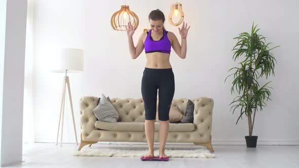 Woman Celebrating Weight Loss Achievement on Scale