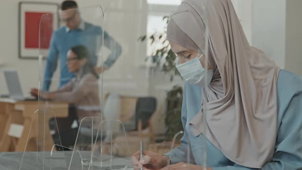 Woman in Face Mask Singing Document at Job Interview