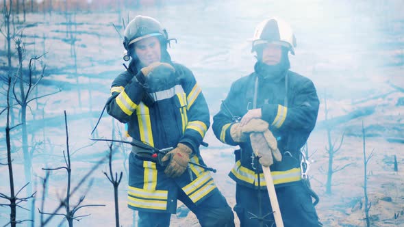 Two Firefighters Standing in the Clouds of Smoke