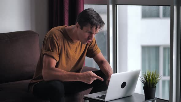 Angry Annoyed Man Screaming and Aggressively Reacting to What He Saw on Screen of Laptop Computer