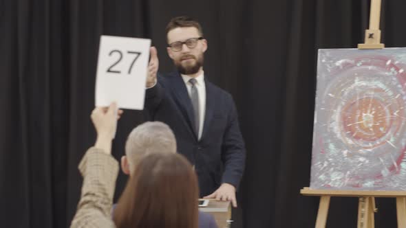 Male Auctioneer Conducting Art Auction