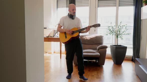 Musician playing guitar at home