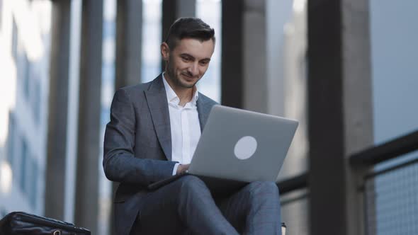 Bearded Man Working With Laptop Computer Outside the Office 