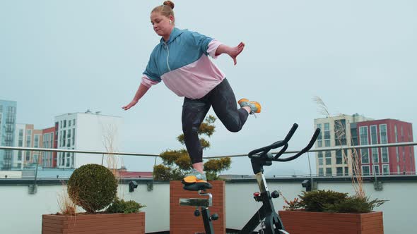 Athletic Woman Performing Swallow Acrobatic Training Trick Workout on Spinning Stationary Bike