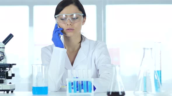 Scientist Sharing Information, Talking on Phone in Laboratory alt