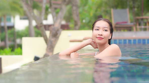 Young asian woman enjoy around outdoor swimming pool for leisure