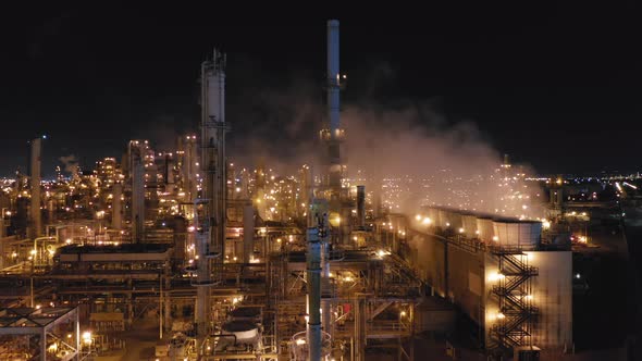 Modern Petroleum Refinery at Night. Smoking Chimneys and Illuminated Constructions. alt