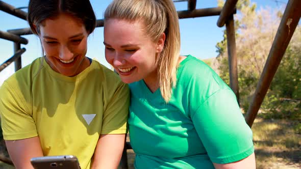 Happy friends using mobile phone in boot camp