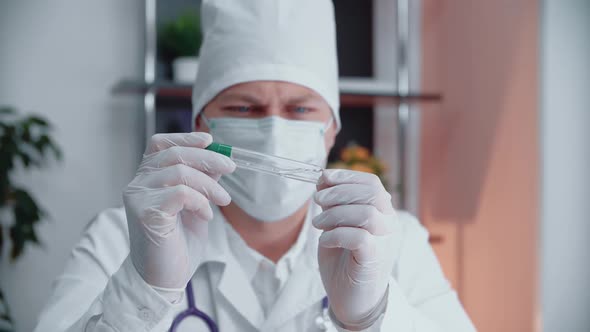 Caucasian doctor man holding a test tube.