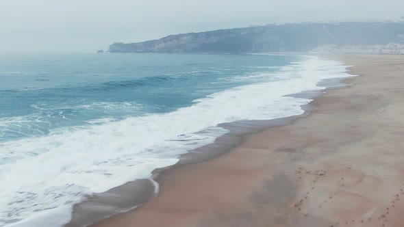 Amazing Waves with White Foam Roll on Clean Sand Upper View