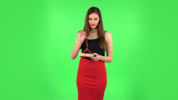 Girl Opens the Gift, Very Surprised and Rejoices. Green Screen