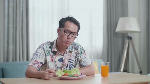 Smiling Asian Man Enjoys Eating Healthy Food At Home