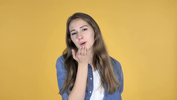 Flying Kiss By Turning Around Pretty Woman Isolated on Yellow Background