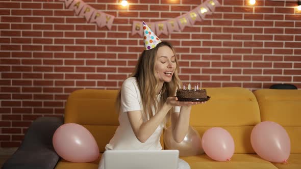 Excited Girl Celebrates Birthday Online By Webcam Holding Cake with Candles