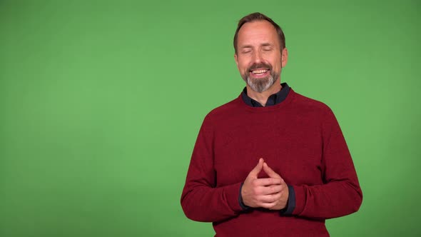 A Middleaged Handsome Caucasian Man Talks to the Camera with a Smile  Green Screen Background