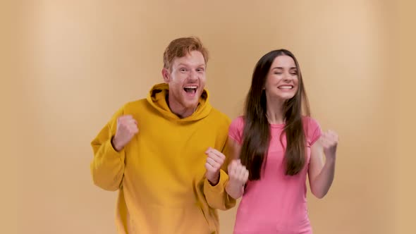 Delighted Emotional Couple Celebrate Victory Raise Fists Scream Yeah Wear Denim Jeans Sneakers