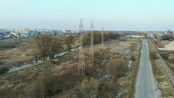 High-voltage electric power poles in field. Drone shot of transmission towers