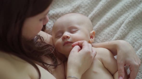 a Beautiful Naked Baby Sleeps in His Mother's Arms