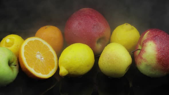 Tropical Lemon, Orange, Apple in Cold Ice Clouds of Fog Smoke on Dark Background