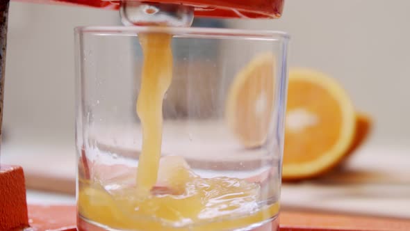 Super slow motion of fresh orange juice squeezed using a manual squeezer