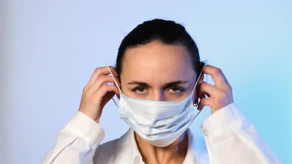 Female Doctor Putting on Mask and Medical Cap