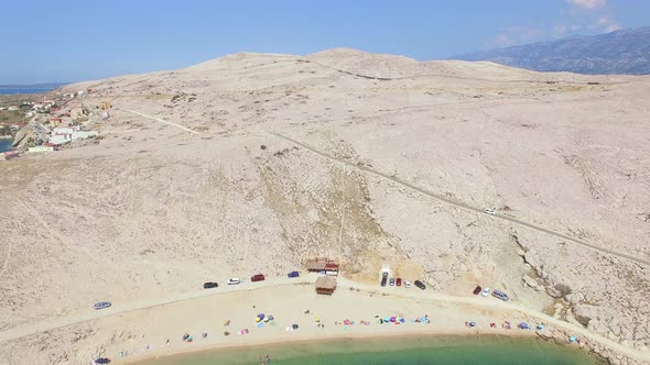 Flying above tourists on isolated beach of Pag island, Croatia