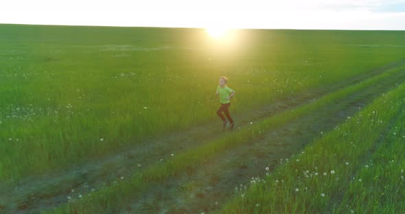 Sporty Child Runs Through a Green Wheat Field