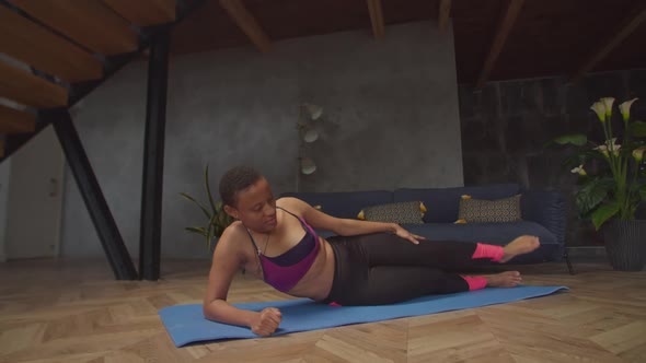 Black Fit Female Doing Side Lying Leg Lift Exercise