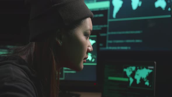Close Up Asian Woman Hacker Using Computer Hacking, Code On Multiple Computer Screens