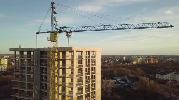 Aerial view of concrete frame of tall unfinished apartment building under construction in a city