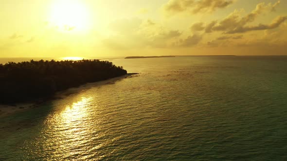 Aerial drone shot scenery of tranquil seashore beach vacation by blue ocean with white sand backgrou