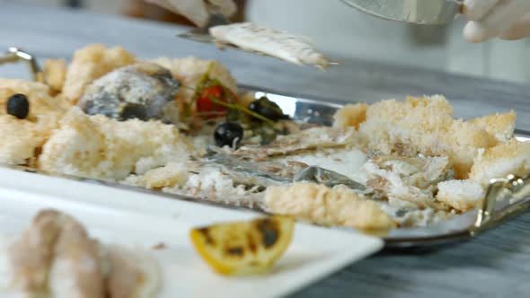 Spatula Puts Fish on Plate.